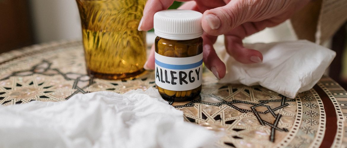 A close-up of allergy medication bottle on table with tissues, ideal for health themes.
